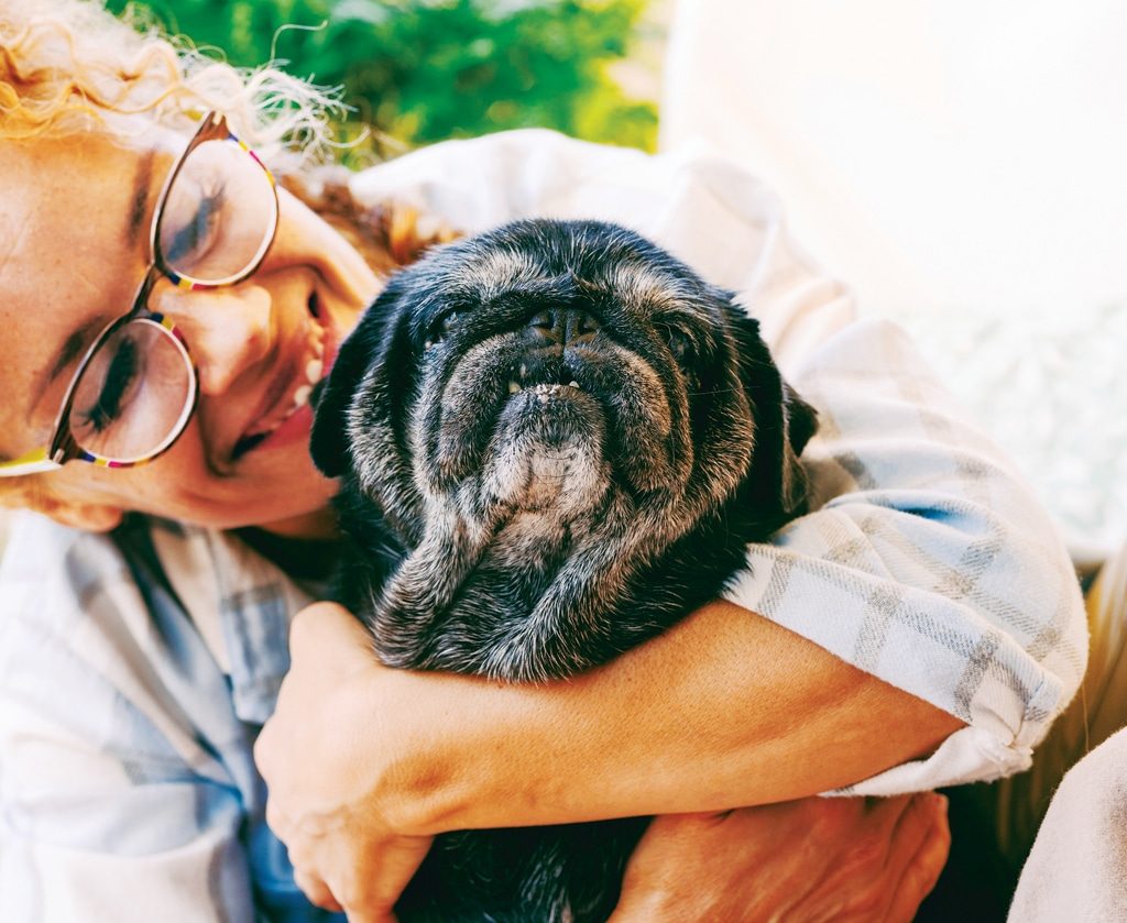 woman holding elderly pug