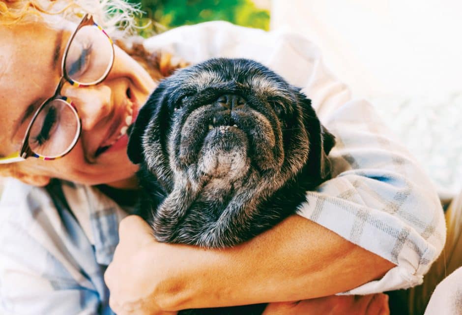woman holding elderly pug